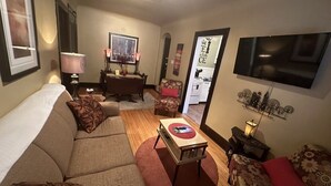 Un salon comprenant un canapé, une table basse, un téléviseur et un coin repas avec des chaises et une table.