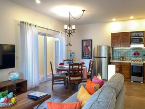 Un appartement moderne comprenant un coin repas, une cuisine et un salon.