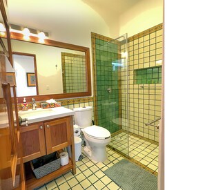 A bathroom with a wooden vanity, a toilet, a shower with a glass door, and a tiled floor. - Newly built 1 bdrm, luxury apartment. Quiet and yet close to everything. (Puerto Morelos)
