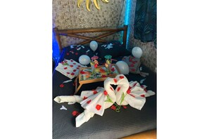 Experience a unique stay in a room featuring a striking bamboo sculpture, a patterned floor, and a bed with a floral design.