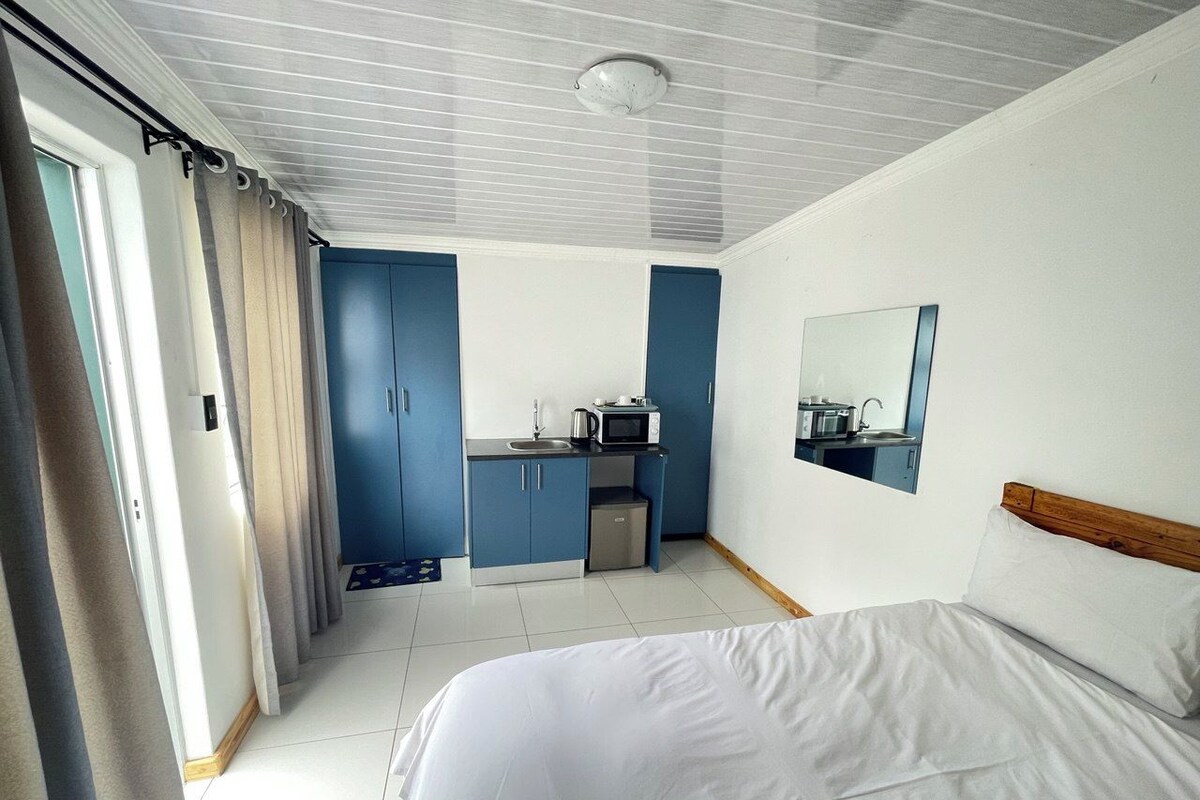Une chambre d’hôtel comprenant un lit, une kitchenette et une salle de bain.