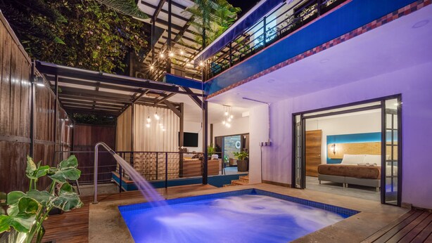 Un espace piscine extérieur moderne doté d’un jacuzzi, d’une terrasse en bois et d’une chambre avec vue.