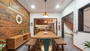 Une cuisine moderne avec des meubles en bois, un four encastré et un luminaire suspendu.