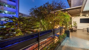 Un jardin sur le toit, agrémenté de diverses plantes et d’un espace aménagé pour s’asseoir.