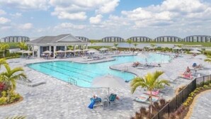 Un complexe hôtelier doté d’une grande piscine, de chaises longues et d’un pavillon abrité.