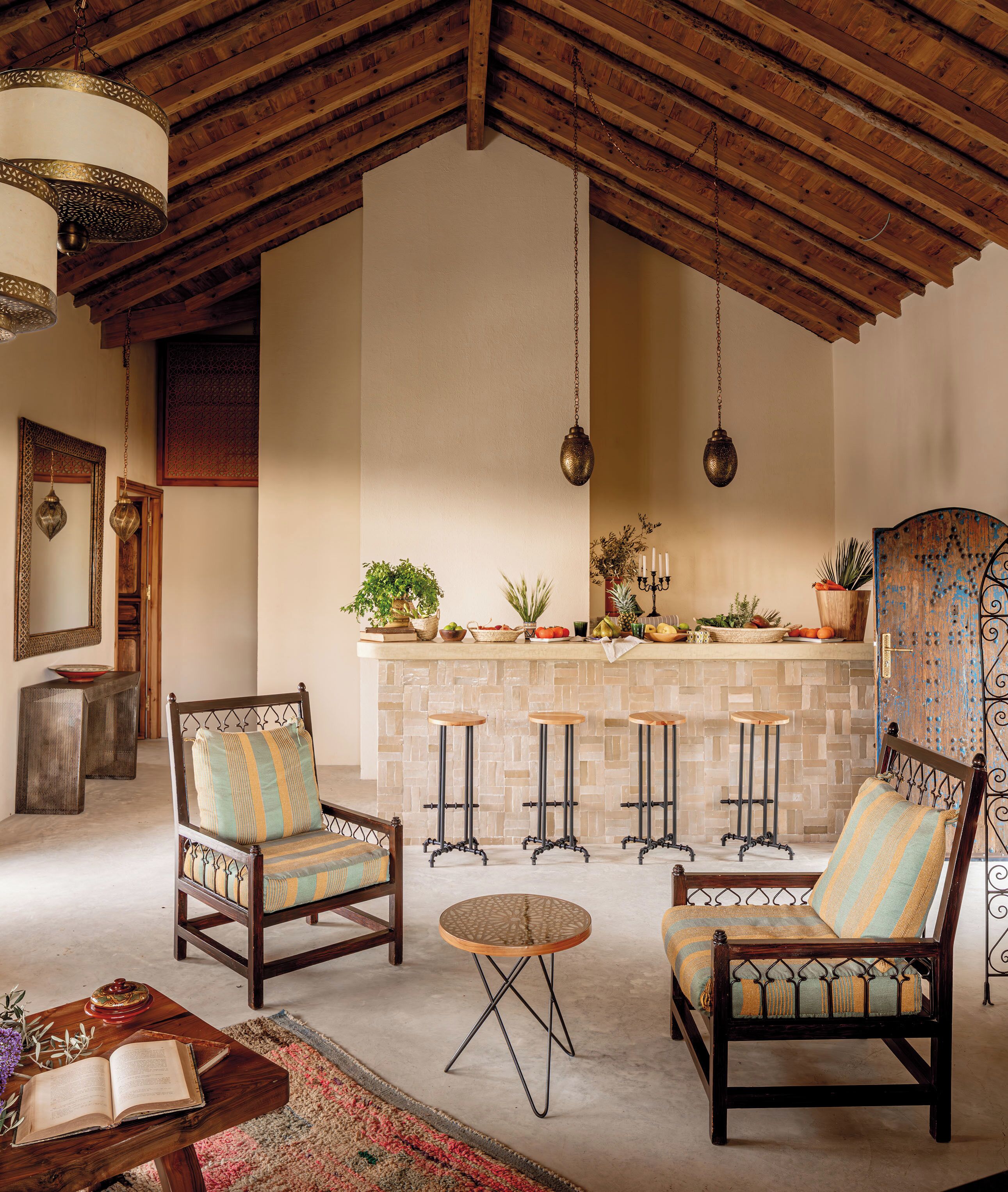 A cozy living room with wooden furniture, a stone fireplace, and hanging lights.