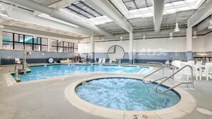 An indoor swimming pool with a hot tub, surrounded by lounge chairs and a tiled wall. - AMAZING OCEANFRONT CONDO - 809 Brandywine House, Sea Colony, Bethany Beach (Bethany Beach)