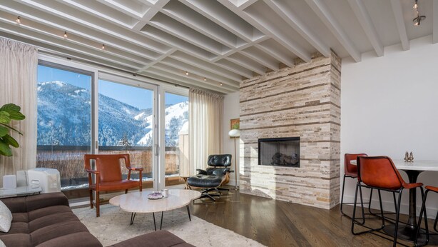 A modern living room with a fireplace, a sofa, a coffee table, and a dining area with chairs. - Sun Valley, Idaho / Downtown Ketchum Penthouse / Views, Ski, Sun, Prime Location (Ketchum)