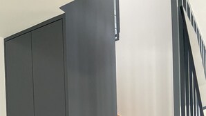 Eine Treppe mit hölzernen Stufen und einer dunkelgrauen Tür.
