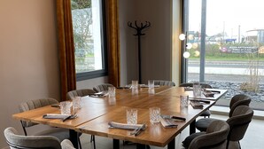 A conference room with a large table, grey upholstered chairs, and a modern chandelier. - Le Vert Bocage (Franqueville-Saint-Pierre)