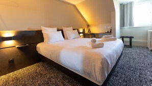 A hotel room with a large bed, a bedside table, a lamp, and a window with curtains. - Le Vert Bocage (Franqueville-Saint-Pierre)