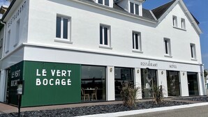 A white building with a green awning labeled "LE VERT BOCAGE" and "RESTAURANT HOTEL" on the ground floor. - Le Vert Bocage (Franqueville-Saint-Pierre)