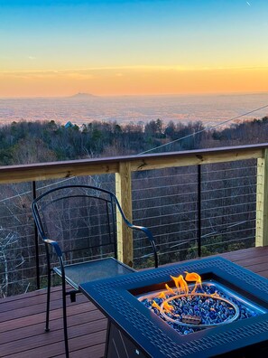Eine Terrasse mit Feuerschale und einem Stuhl, mit Blick auf eine malerische Landschaft.