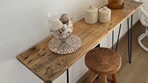 A wooden table with a glass bowl of seashells, a tall vase, and two small containers. - Special vacation villa  (San-Gavino-Di-Carbini)