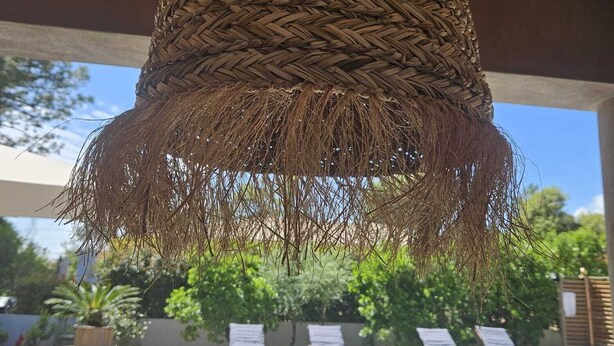 A wooden deck with a pool, lounge chairs, and a hanging woven light fixture. - Special vacation villa  (San-Gavino-Di-Carbini)