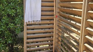 A wooden outdoor shower enclosure with a towel hanging on the door. - Special vacation villa  (San-Gavino-Di-Carbini)
