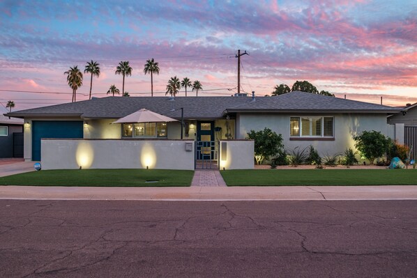 A modern two-story house with a well-maintained lawn, a garage, and a driveway.