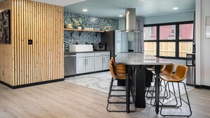 Una cocina moderna con un revestimiento de madera, un salpicadero de mármol y un ventanal.