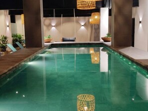 A swimming pool with lounge chairs and potted plants. - Kastel Petrópolis (Petrópolis)