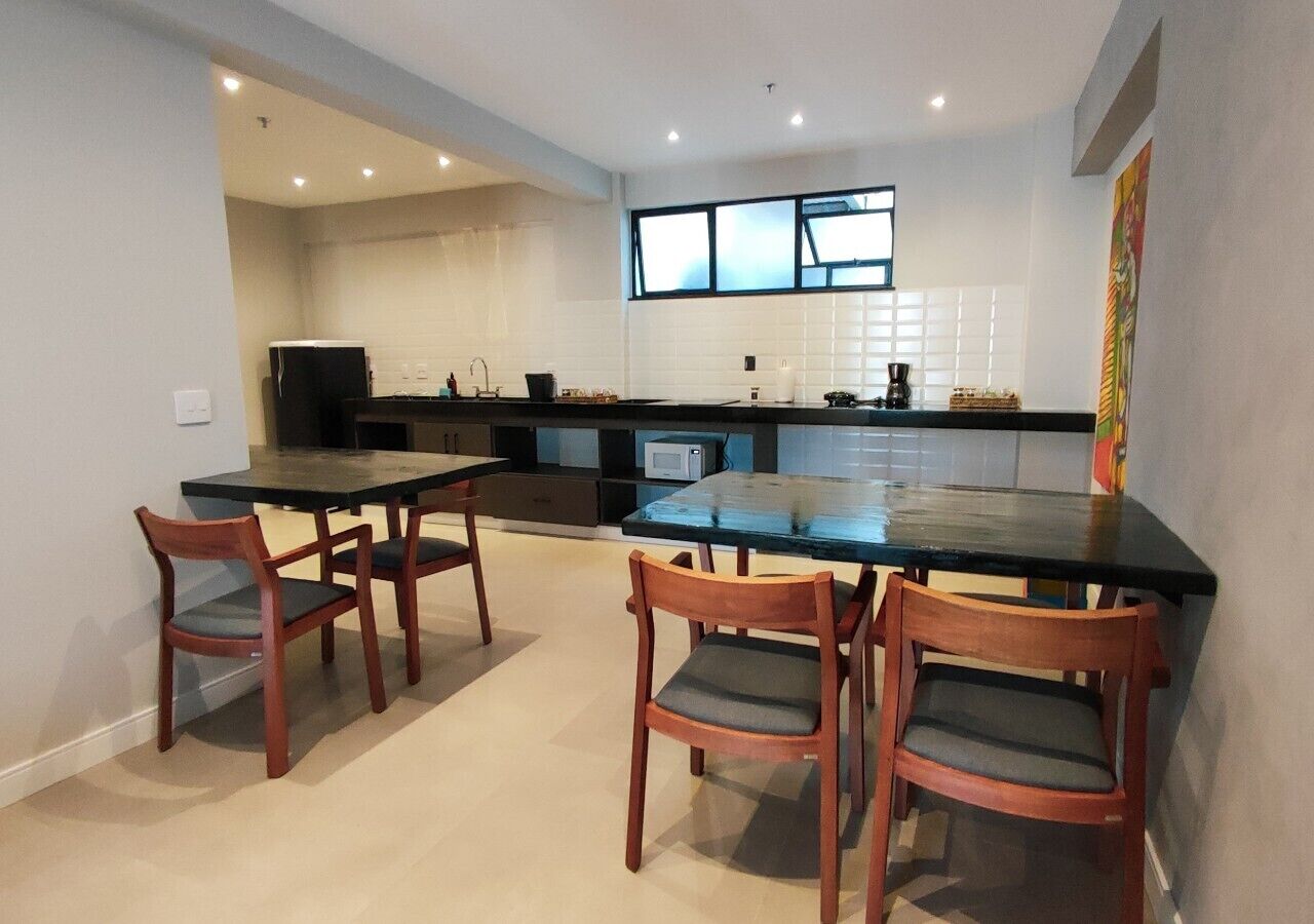 A modern kitchen with a central island, two wooden chairs, and a microwave.