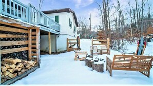 A wooden deck with outdoor seating, a covered area with a railing, and a building with a white exterior. - LAKEFRONT - Lake Escape - Arrowhead Lake Community (Pocono Lake)