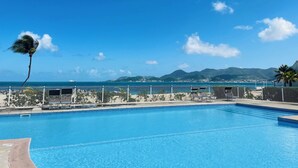 Una piscina con vista al océano y a las montañas.