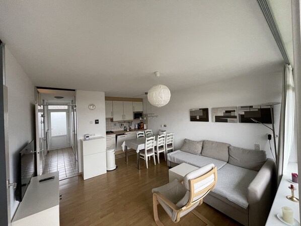 A modern apartment with a dining area, kitchen, and living room.