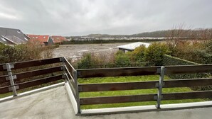 A concrete pathway leading to a grassy area with a wooden fence. - 6 pers. Apartment, 3 sep. Sleeping room, 300 m v. Beach, constantly modernized and clean  (Westkapelle, Zeeland / Walcheren)