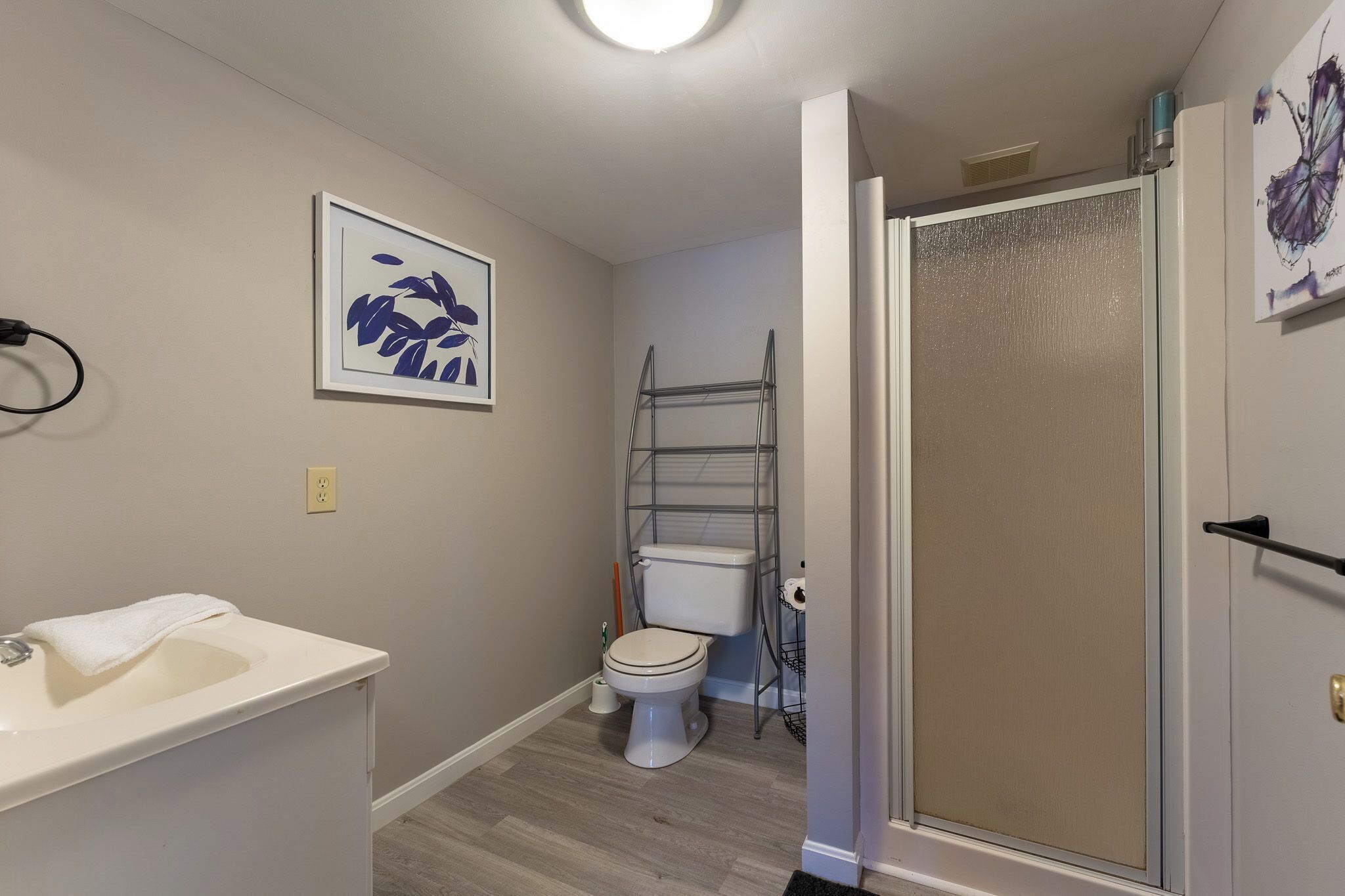 A bathroom with a toilet, sink, and shower area.