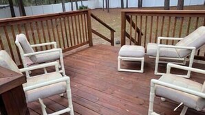 A wooden deck with four white lounge chairs and a small table. - The K Way, The K Way (Ocala)