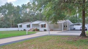 A single-story house with a covered porch and a garage. - The K Way, The K Way (Ocala)