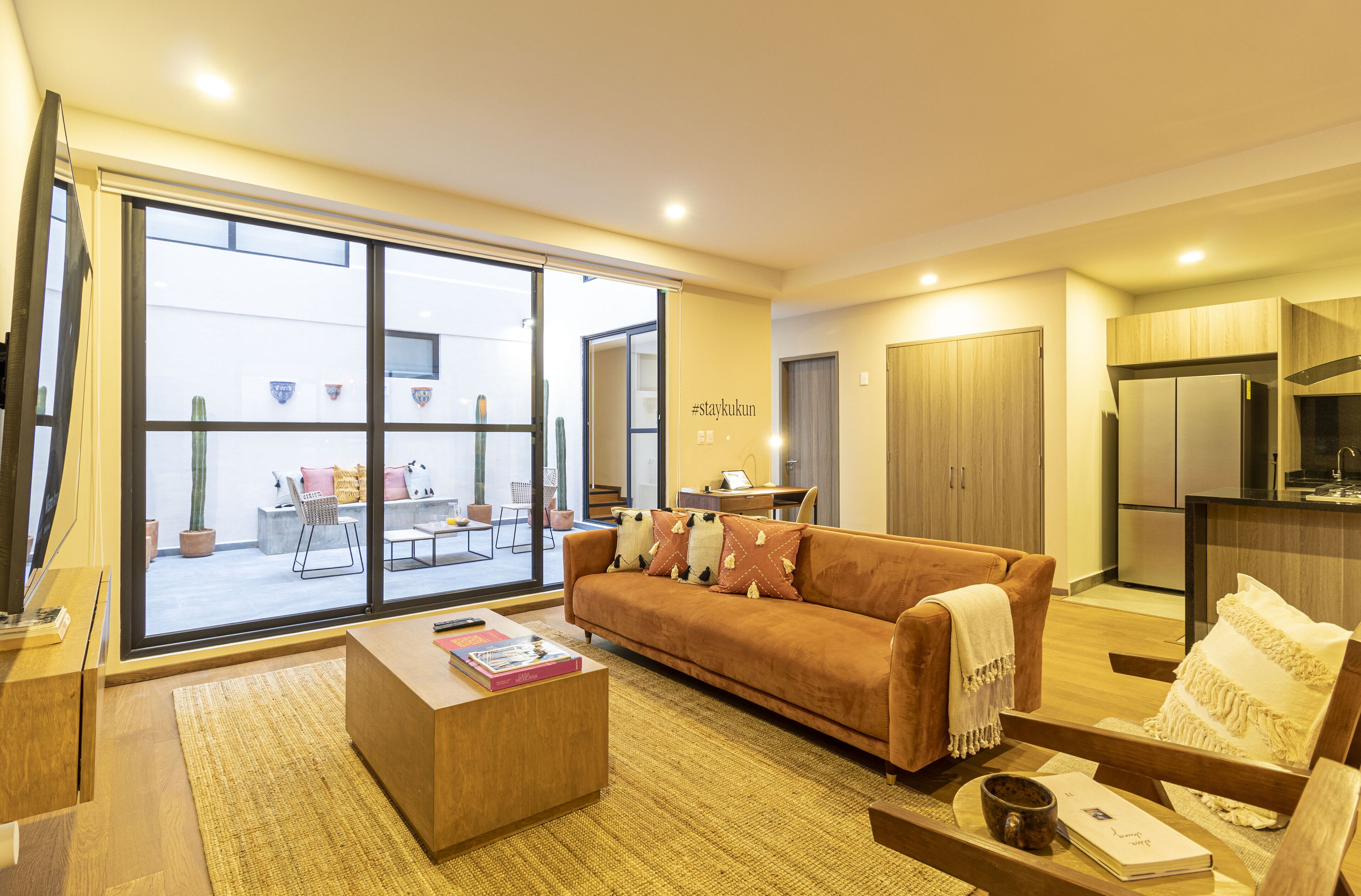 Una sala moderna con sofá, mesa de centro y vistas al exterior.