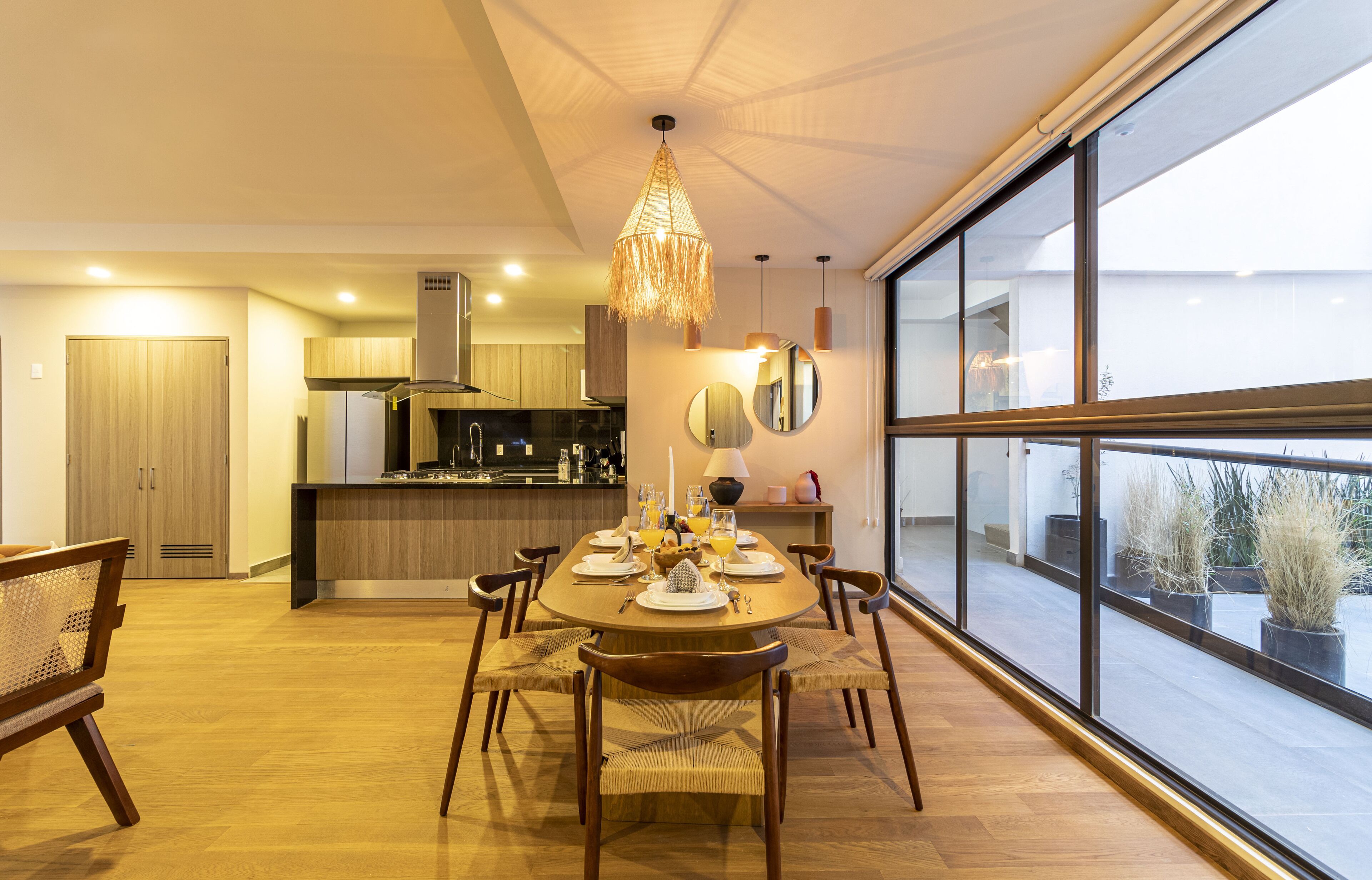 Una cucina moderna con mobili in legno, un tavolo da pranzo per quattro persone e un'ampia finestra con vista sull'esterno.