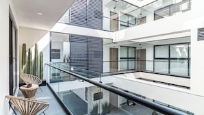 Ein modernes Interieur mit Glastrennwand, mehreren Ebenen und Topfpflanzen.