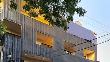 Un edificio moderno de varios pisos con balcones y grandes ventanales.