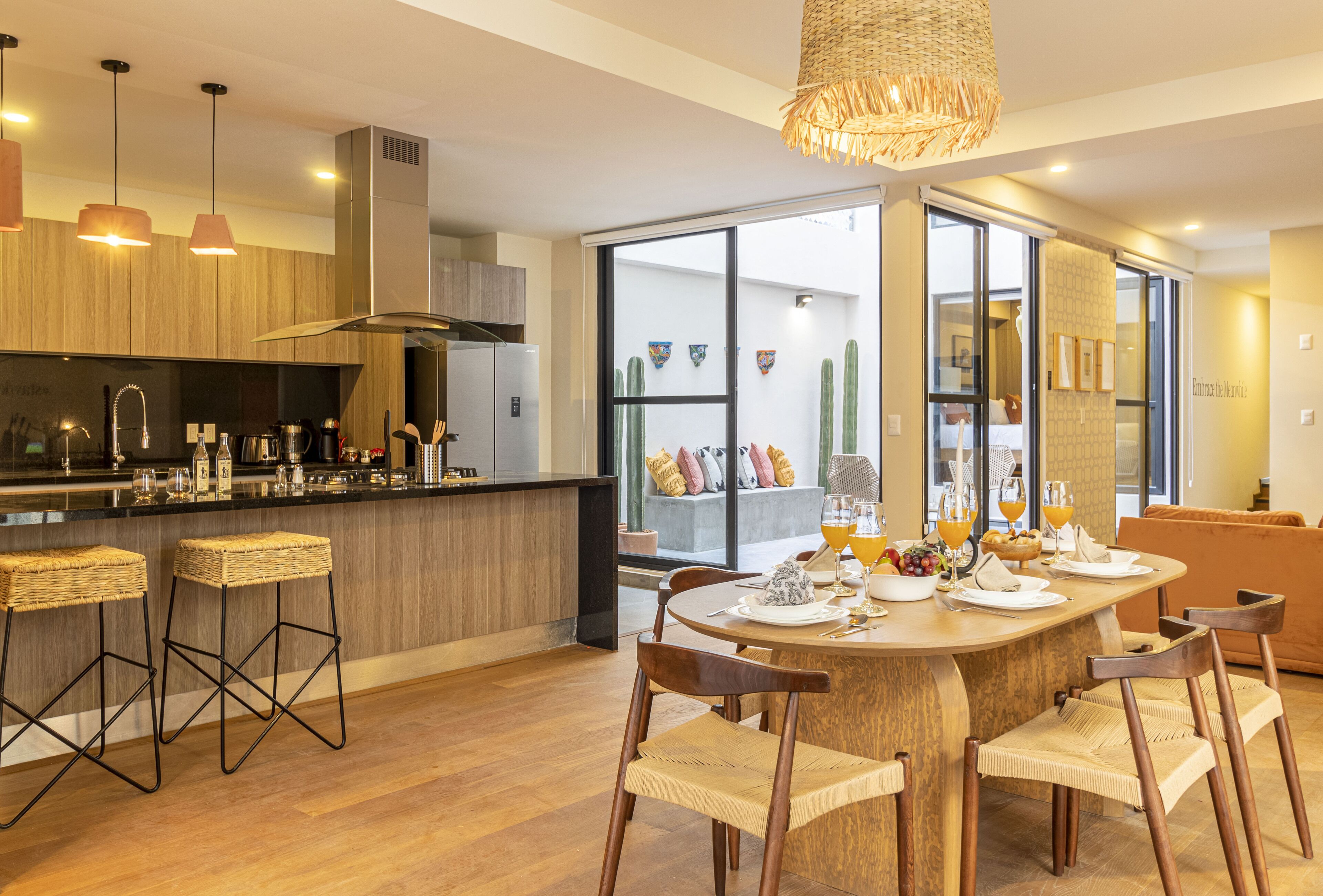 Une cuisine moderne avec un coin repas, un plancher en bois et une grande fenêtre.