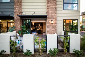 A modern building with a brick facade, a glass entrance, and a small outdoor seating area with plants. - Heritage District Oasis, 300 steps from downtown Gilbert amenities. -Lot 8 (Gilbert)