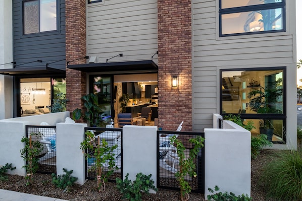A modern two-story building with a brick facade, large windows, and a well-maintained garden area with various plants. - Heritage District Oasis, 300 steps from downtown Gilbert amenities. -Lot 8 (Gilbert)
