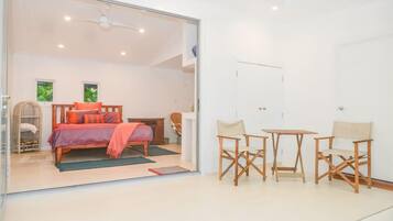 Un dormitorio con cama, una silla, una mesa y un armario.