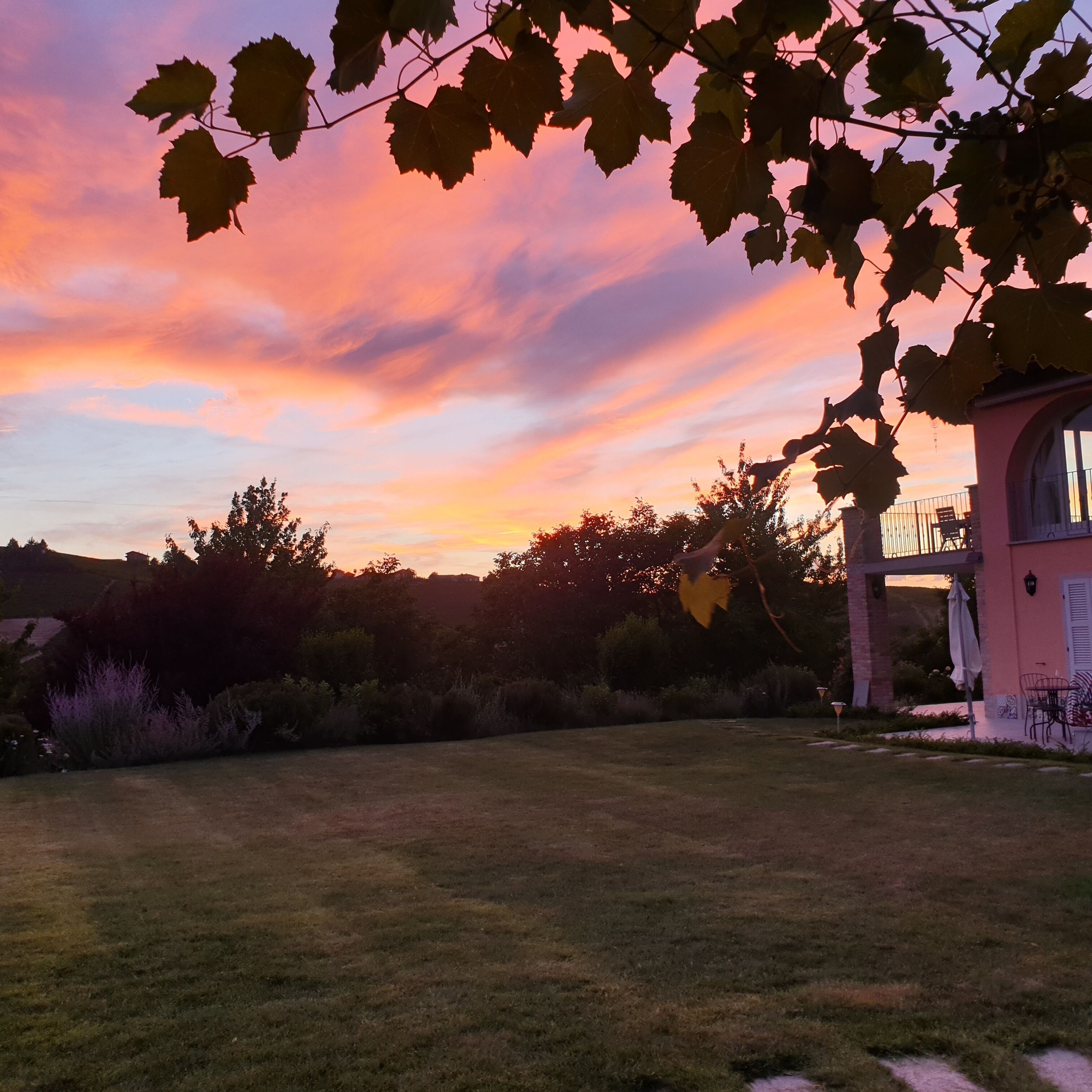 Een huis met terras en uitzicht op een zonsondergang.