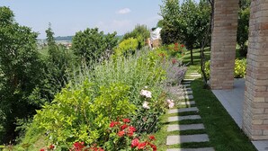 Un jardín con rosas rojas y un sendero de piedra.
