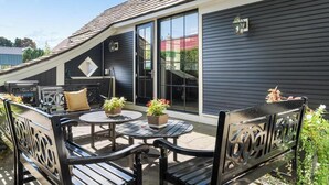 A patio with outdoor furniture, a covered seating area, and a sliding glass door leading to a covered porch. - Downtown 2nd Floor Apartment with Dramatic Lake Views.   (Petoskey)