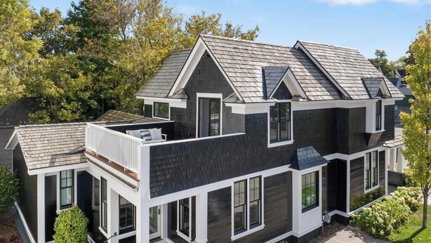 A modern two-story house with a dark exterior, white trim, and a sloped roof. - Downtown 2nd Floor Apartment with Dramatic Lake Views.   (Petoskey)