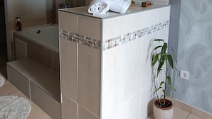 A bathroom with a bathtub, a sink, and a potted plant. - Romantic villa with whirlpool bath 5mns from the beach! (Saint-Leu)