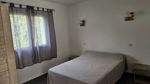 A bedroom with a bed, a window with curtains, and two wall-mounted lamps. - Mini villa T3 by the sea at Marine de Sisco, Cap Corse (SISCO)