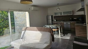 A modern bedroom with a large bed, a dining area, and a kitchen. - Mini villa T3 by the sea at Marine de Sisco, Cap Corse (SISCO)