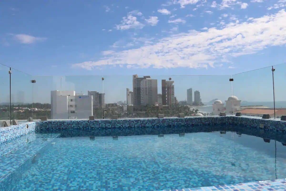 A rooftop swimming pool with a cityscape view.