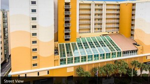 Un hotel de varios pisos con un atrio central, balcones y techo plano.