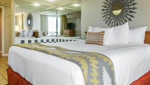 Una habitación de hotel con una cama grande, un espejo y un adorno en la pared.