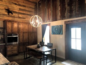 Cozy kitchen with a wooden dining table and stainless steel oven.